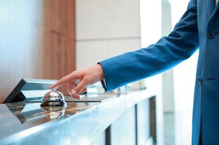 Staff Shortages: person ringing bell in hotel